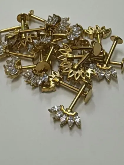 This is our popular Bugadi stud in a gold-plated finish. The design features a delicate, leaf-like pattern with marquise-cut crystals, combining traditional aesthetics with modern piercing styles.