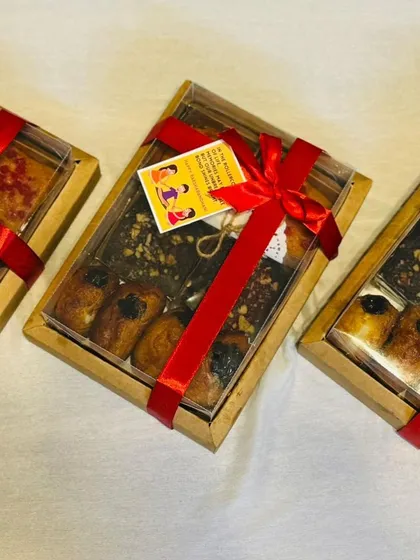 Here are multiple budget-friendly Rakhi hampers, all packed and ready for gifting. Each box contains a delicious assortment of my homemade baked goods, tied with a festive red ribbon.