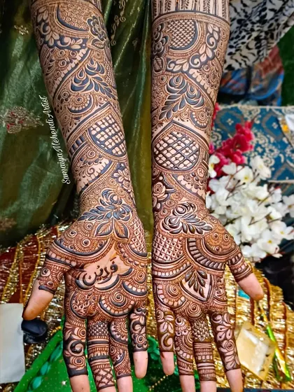 A classic full coverage bridal mehendi with a mix of styles. You can see the delicate jaali (net) patterns, leafy motifs, and a space in the palm for the bride's name in beautiful Arabic calligraphy.