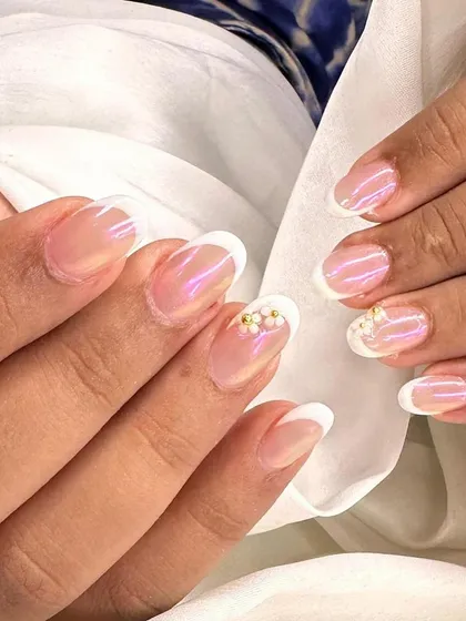 A different angle of the pearly flower accent on a classic French manicure. The iridescent base gives the nails a beautiful, healthy glow.