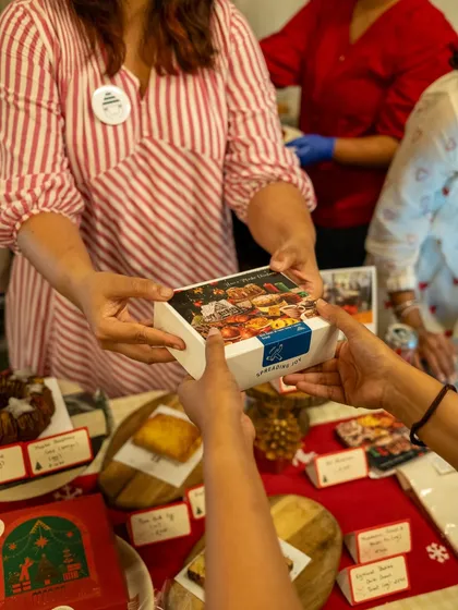 Handing over a box of our Christmas treats at a festive pop-up. Our gift boxes are a popular choice for sharing the holiday spirit with friends, family, and colleagues.