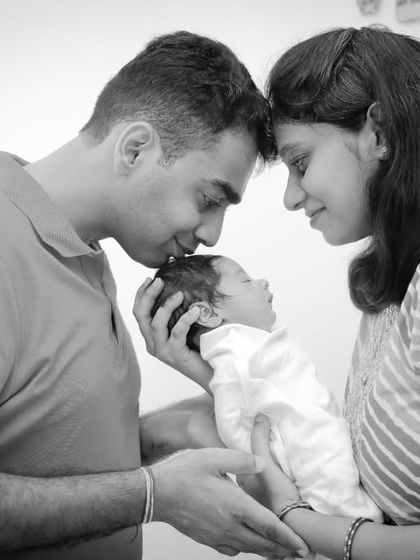 A new family adoring their baby. This black and white photo focuses on the love and intimacy of this precious moment.