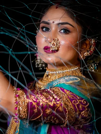 A creative shot of a bride in a traditional Koli (fisherwoman) look for Narali Purnima. The makeup is bold and vibrant, matching the festive spirit.