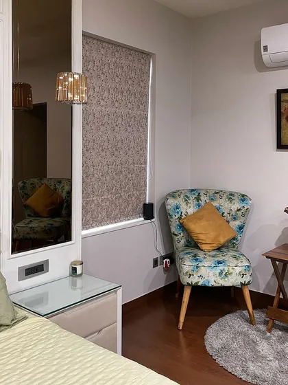 Every bedroom needs a cozy corner. Here, we created a small seating area with a floral accent chair and a side table, perfect for enjoying a cup of tea or reading a book by the window.
