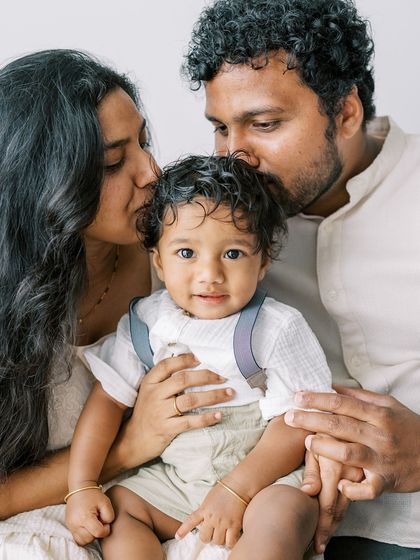 A happy family portrait. The baby's bright eyes and the parents' loving smiles make this a perfect shot.