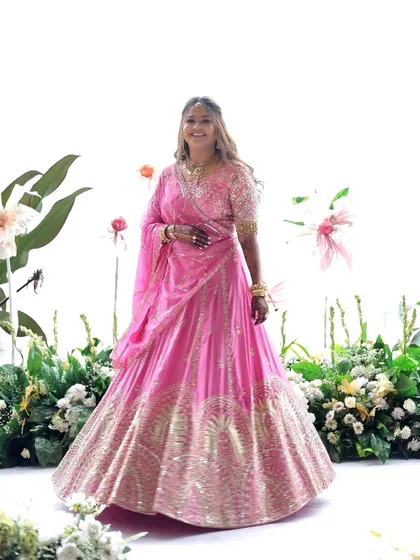 A full-length view of this bride's gorgeous pink lehenga. The soft, natural makeup ensures she looks like herself, just more special, and is comfortable enough to enjoy her big day to the fullest.