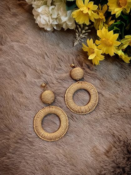 A beautiful flat-lay of the bohemian woven straw dangle earrings, perfect for your next vacation.