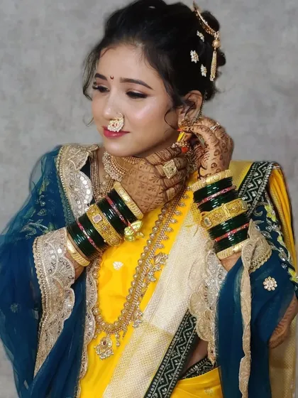 A candid shot capturing the elegance of the Maharashtrian bride, with attention to the nath and bangles.