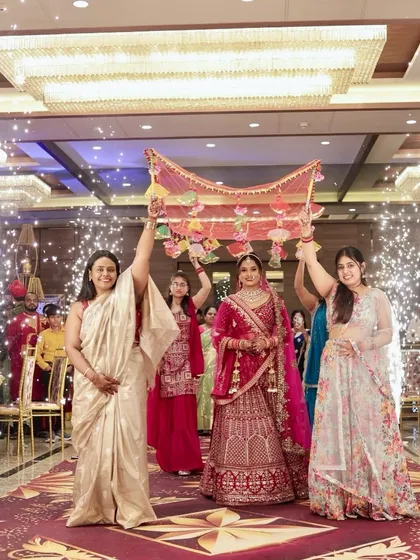 The bride's grand entrance under a floral canopy, looking every bit the princess she is.
