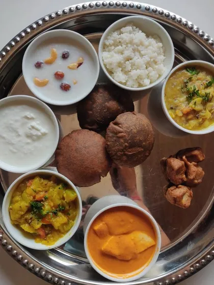 A complete Navratri special thali. This platter includes a variety of fasting-appropriate dishes like Kuttu ki Poori, Samak rice, and paneer curry, all prepared without onion or garlic.