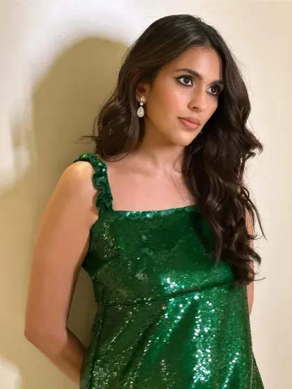 A close-up of the green Ganni sequin dress, showing its sparkle and the simple, chic silhouette.