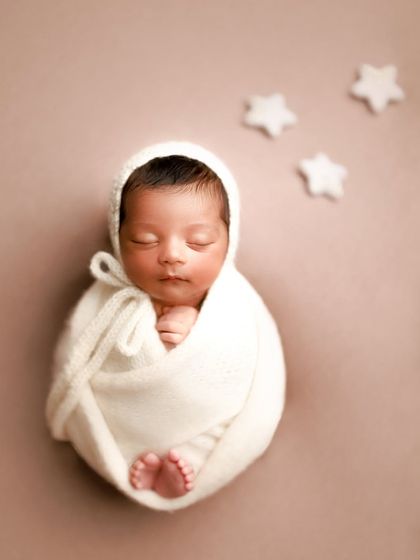 Isn't he adorable? A simple, minimal shot with the baby wrapped in white against a neutral background, with just a few stars to add a touch of magic.