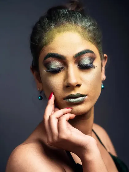 A 'Green Fairy' fantasy look, perfect for a creative portfolio. This look features a green-tinted base, metallic green lips, and dramatic smoky eyes with large lashes to create an ethereal and magical character.