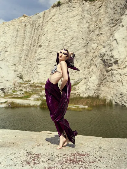 A striking full-length pose where the makeup and hair contribute to a powerful, statuesque silhouette.