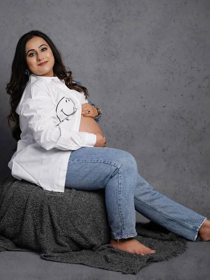 A relaxed and happy solo portrait in a casual, fun outfit, showing that maternity shoots can be comfortable and stylish.