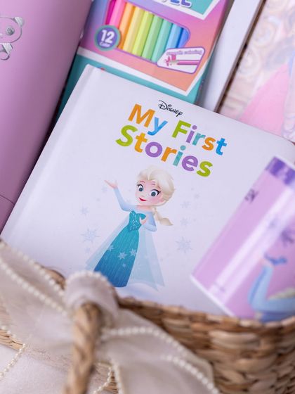 A detail shot of the 'Frozen' storybook and mug inside the wicker basket, showing how the items are carefully arranged.