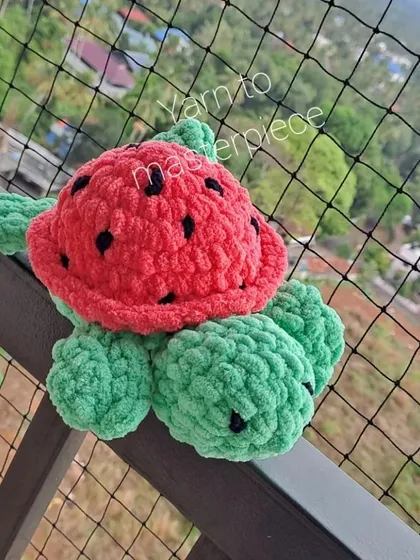 A plush watermelon turtle enjoying some fresh air.