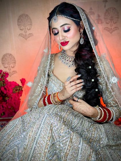 A candid shot showing the intricate braided hairstyle adorned with pearls. The makeup is kept fresh and glowing.
