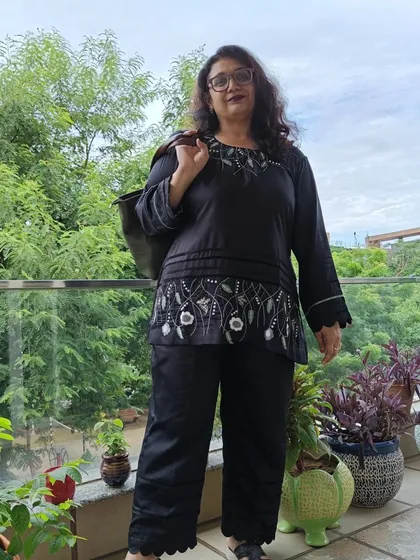 This full-length view shows the complete black co-ord set, including the stylish scalloped hem on the pants. It's a perfect example of smart, casual elegance.