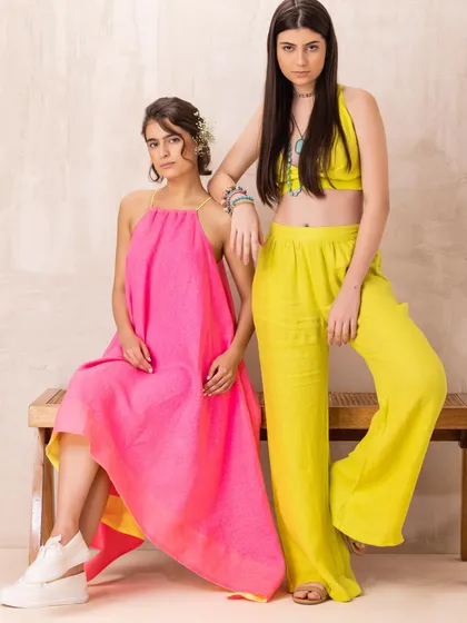 A vibrant shot from a summer linen campaign, featuring models in bright pink and lime green outfits. This styling choice was made to evoke a feeling of fun and tropical energy.