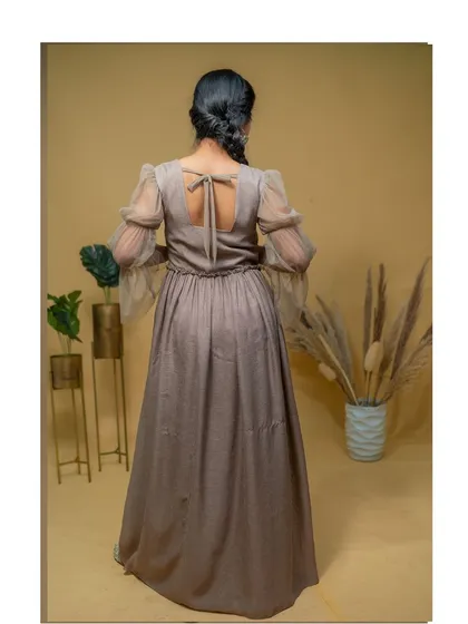 The back of the dress features sheer net sleeves and a tie-up detail, adding a touch of modern femininity.