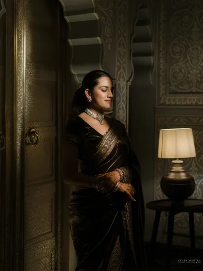 A portrait in shadow and light. I styled this moody, intimate shot of the bride in a deep velvet Sabyasachi saree, using a single lamp to create a dramatic, painterly effect that highlights the richness of the fabric and her diamond necklace.