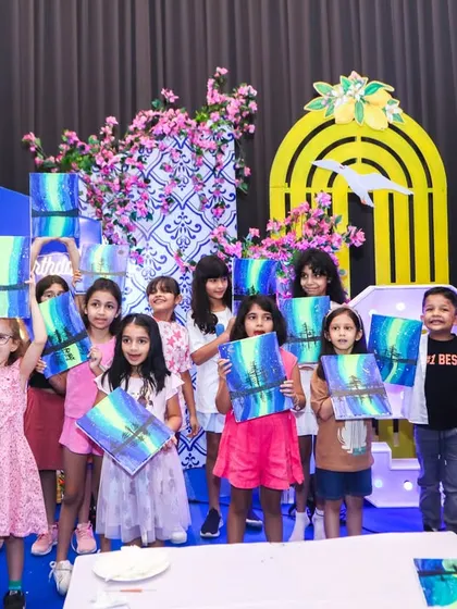 We believe in fun that sparks creativity. Our art party stations are a huge hit, where kids get to create their own masterpieces to take home, as seen in this happy group shot from a Greece-themed painting party.