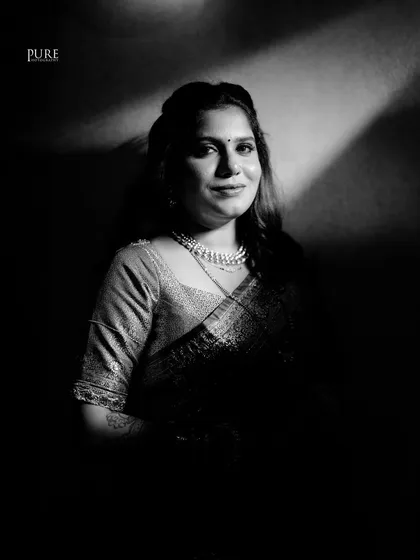 A beautiful black and white portrait of the bride looking directly at the camera. Her confident smile and elegant saree make for a powerful shot.