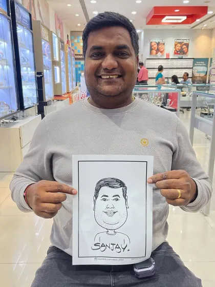 A customer at a Titan Eye+ store in Kurla mall, happy with his new caricature.