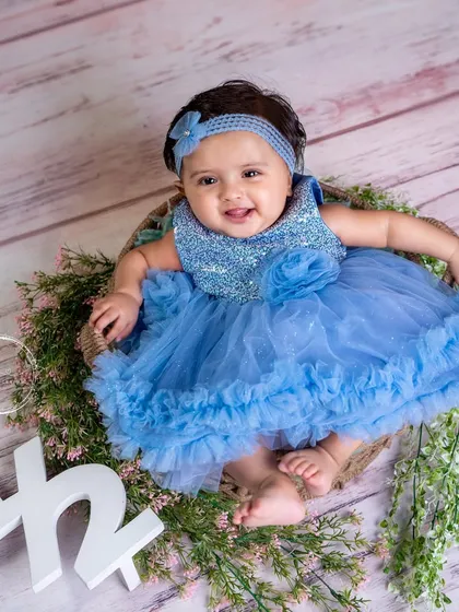 Halfway to one! This six-month milestone is celebrated with a beautiful blue dress and a floral wreath prop.