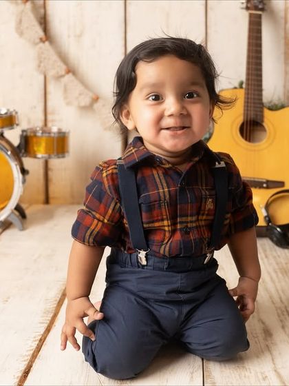 Posing like a true musician. This toddler's personality shines in his plaid shirt and suspenders during his rockstar-themed sitter session.