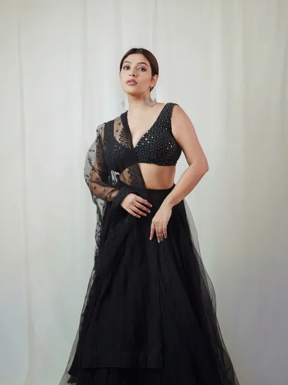 A full-body shot showcasing the entire black lehenga outfit, highlighting its modern silhouette and delicate details.