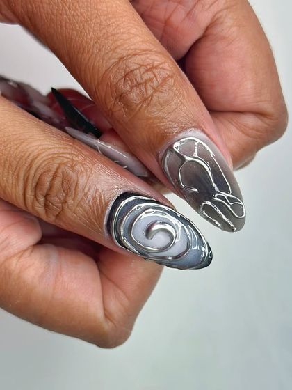 A close-up of the gothic/techno nails, showing the 3D silver chrome work that gives the design its unique texture.