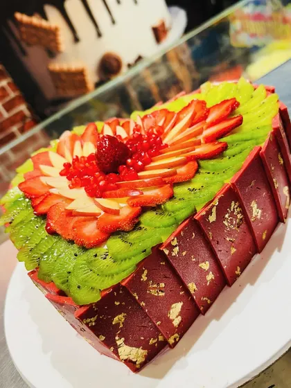 Another angle of the stunning fresh fruit heart cake, showing the geometric chocolate collar.