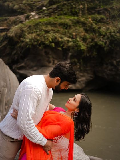 A romantic dip by a riverside in Manali, combining the beauty of flowing water and a loving embrace.