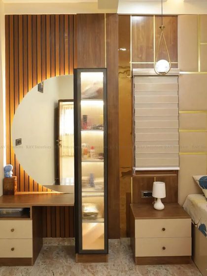 A bedroom with a unique dressing unit, featuring a circular mirror and a hidden, lit-up storage cabinet.