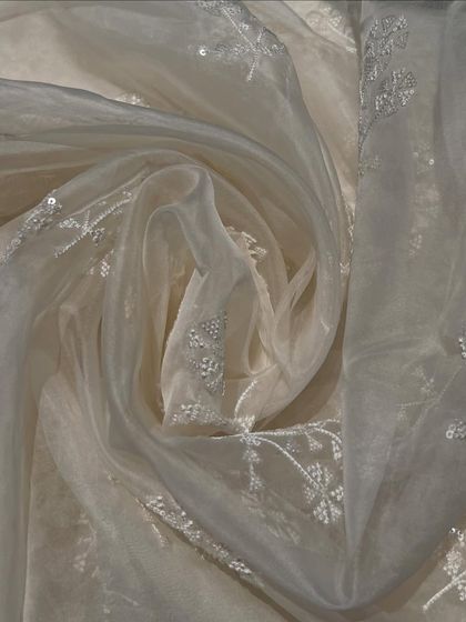 This swirled view of my pure organza highlights its delicate nature. The intricate white-on-white pani tikki embroidery offers a subtle sparkle, ideal for a classic and graceful ethnic suit.