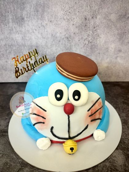 Hello, Doraemon! This cute 3D cake is made with whipped cream and features Doraemon's happy face, complete with his bell and a Dorayaki on his head.