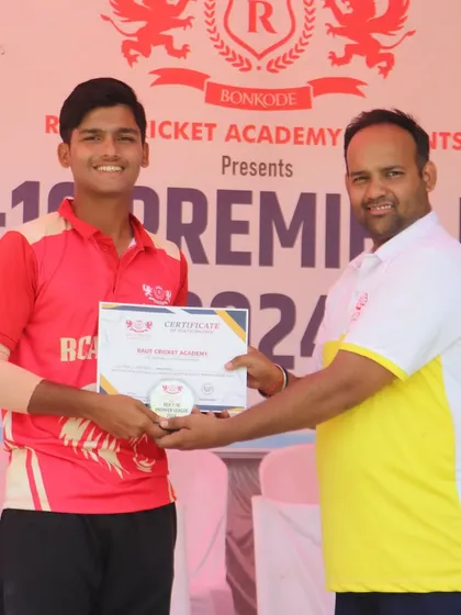A smiling player from the RCA Kings team is recognized for his winning contribution.
