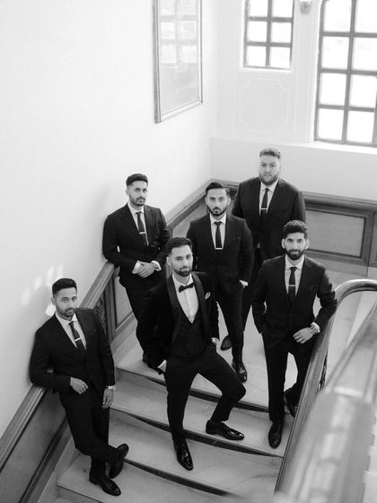 A classic group portrait of the groom and his groomsmen on a staircase. The different levels and poses create a dynamic and stylish composition.