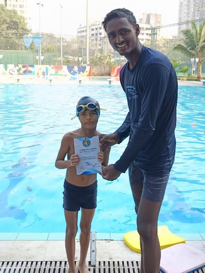 A proud moment at our swim school as a young student receives his certificate for advancing to the next level of his training.