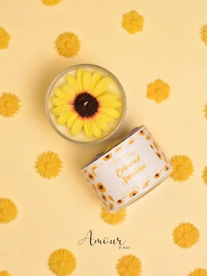 A sunny, top-down view of my yellow sunflower candle from the Sunshine Trio box. It's handcrafted to bring a little bit of sunshine indoors.