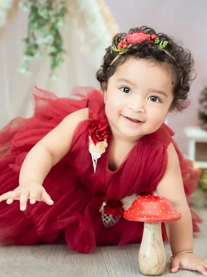 A whimsical woodland theme with a red tutu and mushroom prop. This setup is perfect for a fairytale-inspired photoshoot.