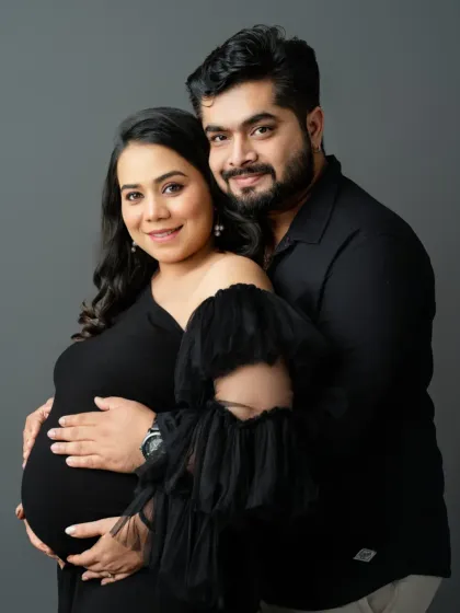 This pose beautifully frames the baby bump, with both parents' hands creating a circle of love and protection.