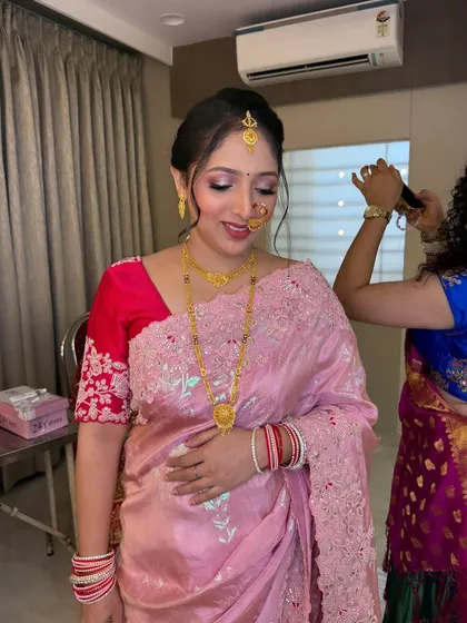 A behind-the-scenes shot showing the final touches on her hair, with the makeup already looking perfect.