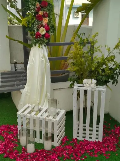 The side decor elements, including floral arrangements and candles in glass holders, which complement the main arch.