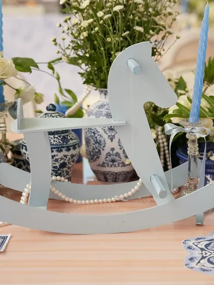 A pale blue rocking horse adds a classic, nostalgic touch to the baby shower decor.