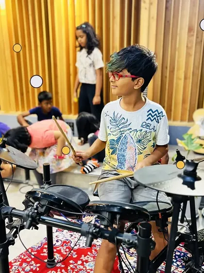 Finding your rhythm and having a blast! This young drummer is completely in the zone, learning the fundamentals of beat and timing on an electronic drum kit. Our camp is all about hands-on experience with real instruments.