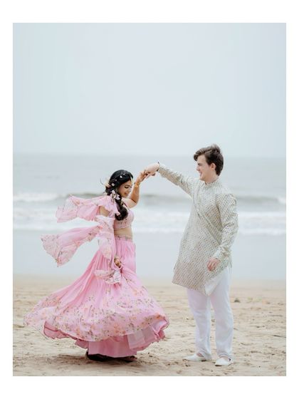 A beautiful shot of the groom twirling his bride on the beach. Her flowing lehenga and the ocean backdrop make this a dreamy, cinematic portrait.