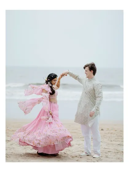 A beautiful shot of the groom twirling his bride on the beach. Her flowing lehenga and the ocean backdrop make this a dreamy, cinematic portrait.